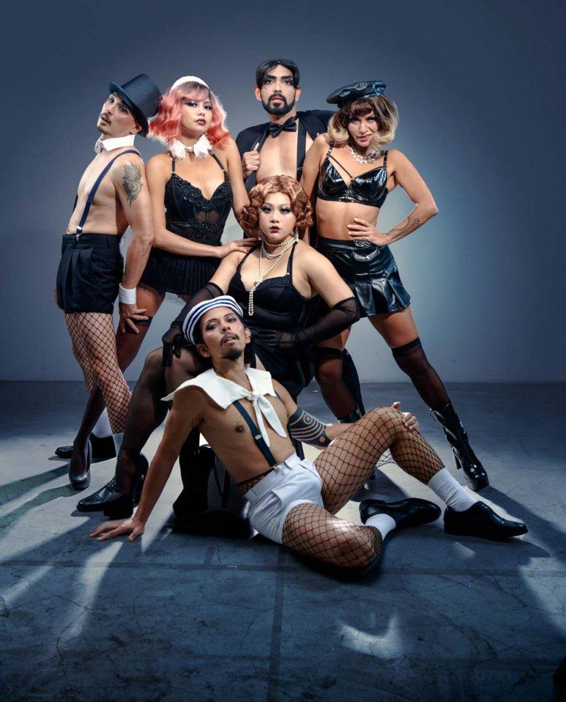 Cabaret cast in costume posed together for a studio group portrait. professional portrait photographer for commercial photography with a group of dancers in studio. advertisement images for theatre performance publicity