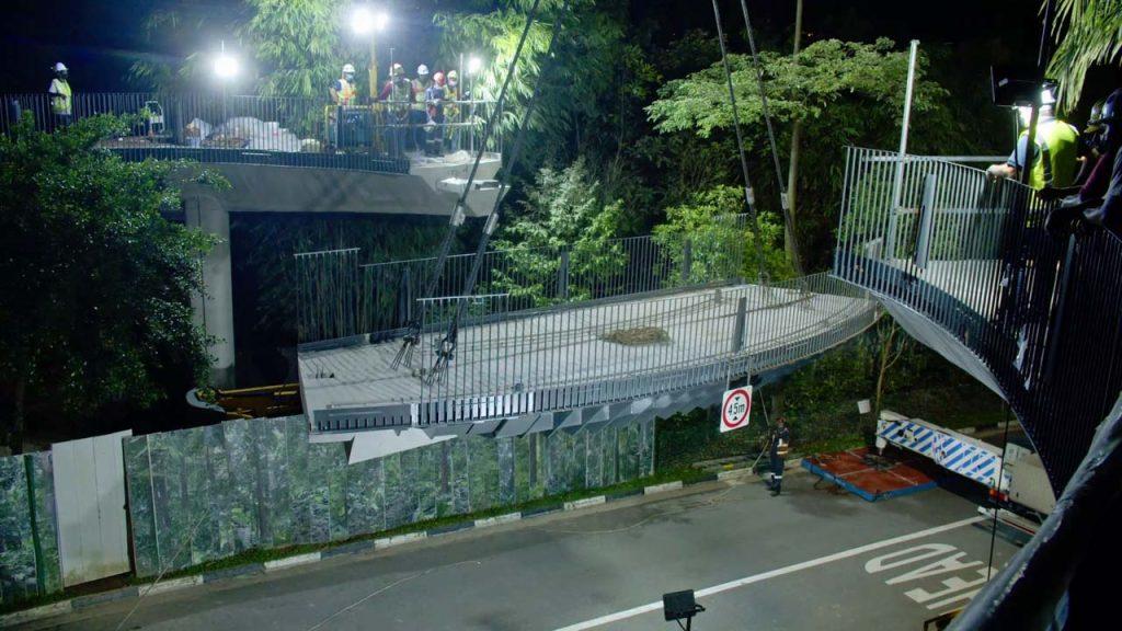 Night lift of a precast bridge section under floodlights at the Gallop Extension.