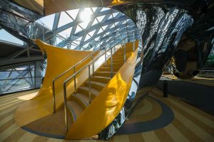 Yellow stairs inside the chrome Discovery Slides at Jewel Changi Airport, commercial photography