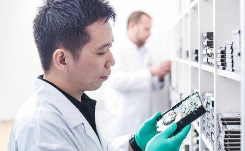 lifestyle photography of lab engineer examining a hard disk