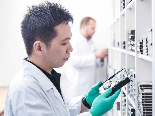 lifestyle photography of lab engineer examining a hard disk — professional portrait photographer singapore, portrait photography singapore