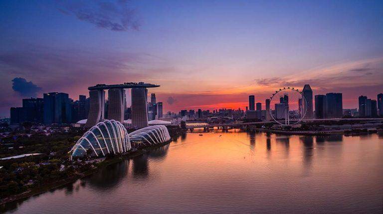 Marina Bay at sunset with the Gardens by the Bay domes and Marina Bay Sands in silhouette against the afterglow