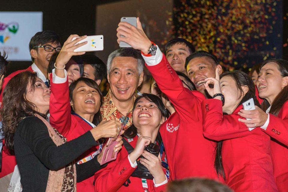 Corporate events photography of a joyous occasion during the celebratory dinner with guest taking selfie photos with the Prime Minister