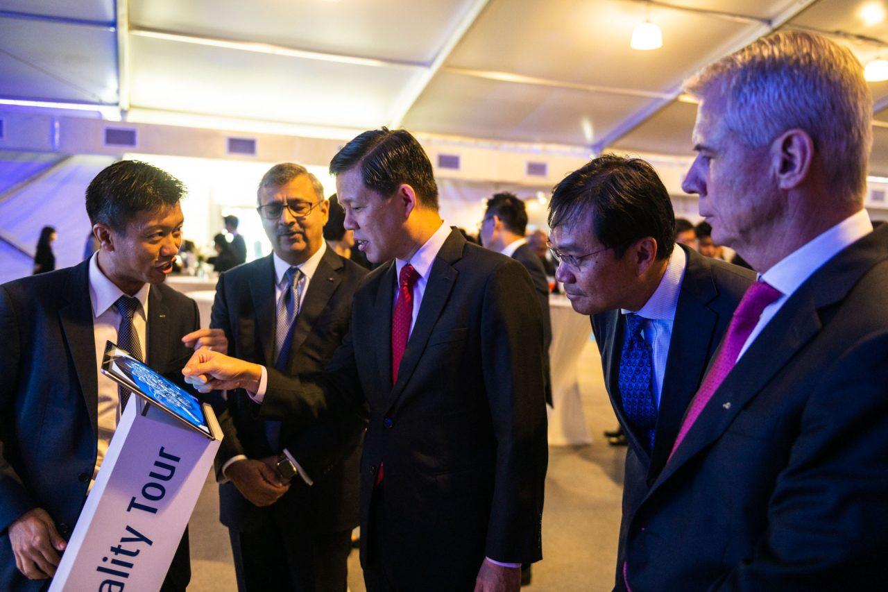 Minister Chan Chun Seng and Linde GM engage in discussion at an event. He points towards an interactive panel labeled "Virtuality Tour" while the others observe and converse.
