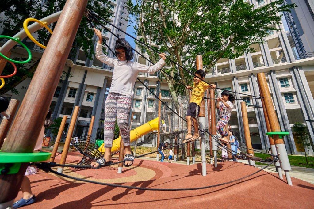 Bespoke playground photography of children joyfully engaging with unique playground equipment in an urban setting. Bespoke playground photography of children joyfully engaging with unique playground equipment in an urban setting, framed by modern residential buildings