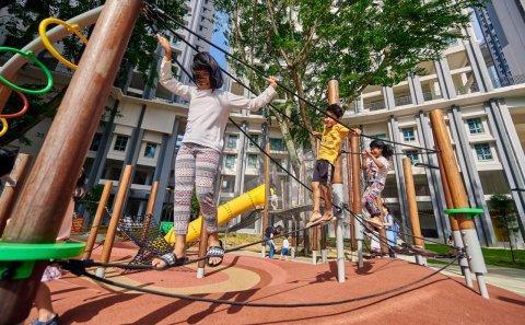 Bespoke playground photography of children joyfully engaging with unique playground equipment in an urban setting, framed by modern residential buildings