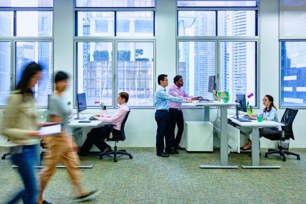 Staff at sit-stand desks in a Singapore office, corporate photography and videography