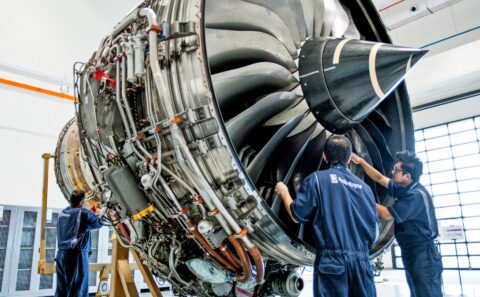 A turbofan engine on its stand in the MRO bay while technicians work on it. Aviation and aerospace photography in Singapore.