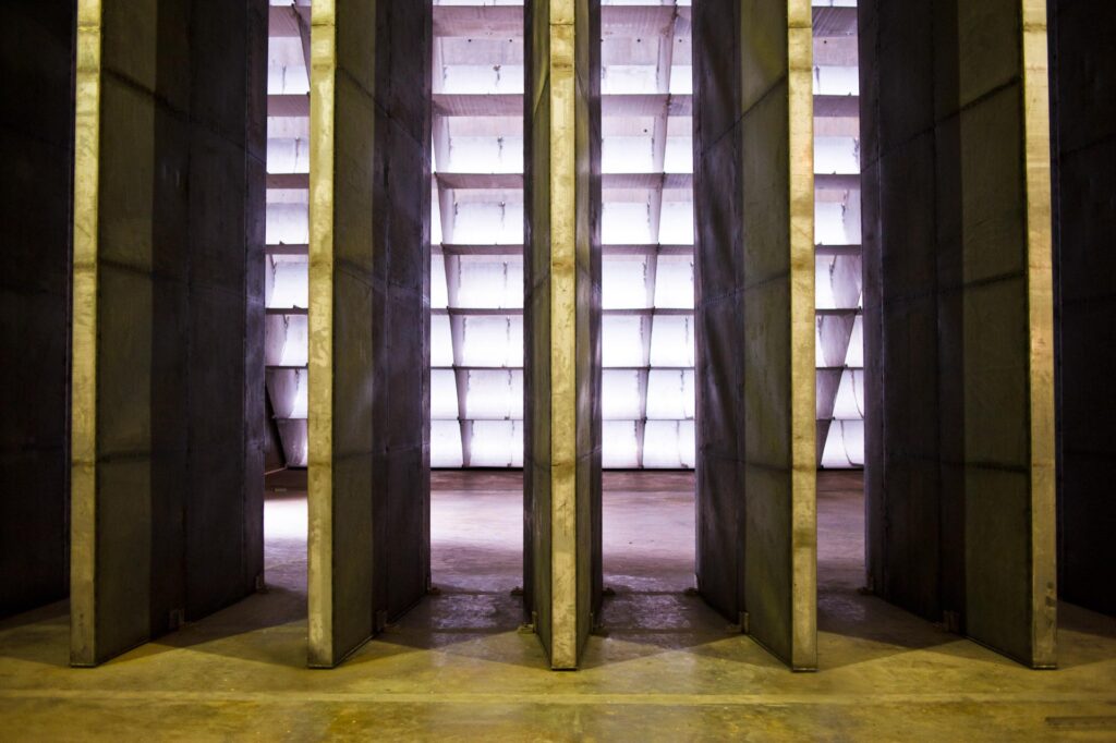 Vertical steel acoustic splitter panels inside the Rolls-Royce Seletar engine test cell, backlit by the intake wall