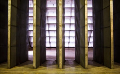 Vertical steel acoustic splitter panels inside the Rolls-Royce Seletar engine test cell, backlit by the intake wall