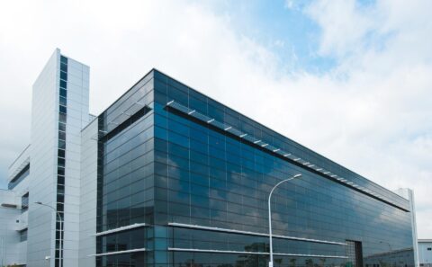 Glass and aluminium office building at the Rolls-Royce Seletar campus, Singapore, under a blue sky with white cloud